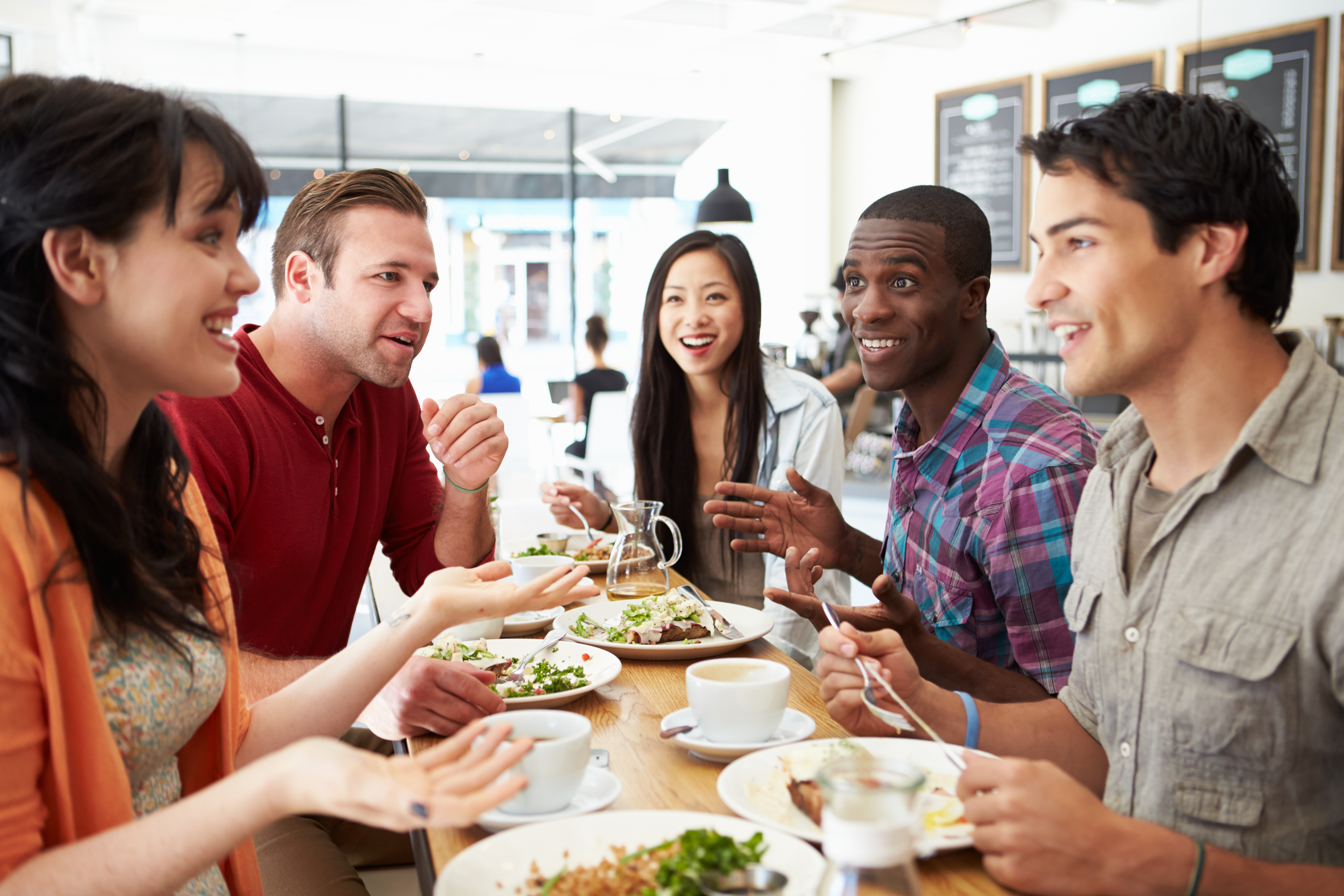 Group Of Friends Meeting For Lunch In Coffee Shop 