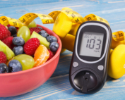Fruit salad, glucose meter, centimeter and dumbbells, diabetes, healthy lifestyle and nutrition concept